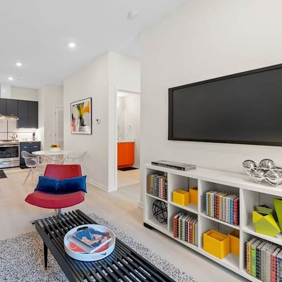 a living room with a tv and a kitchen in the background