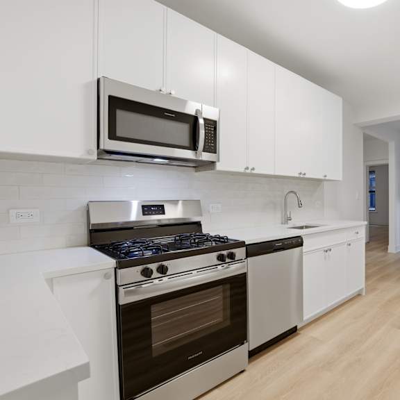 a kitchen with white cabinets and stainless steel appliances.