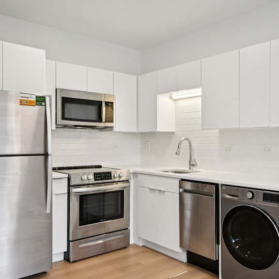 a kitchen with a stainless steel refrigerator, microwave, oven, and dishwasher.