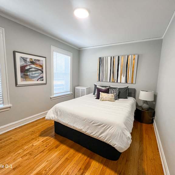 a bedroom with a bed, nightstand, and a painting on the wall.