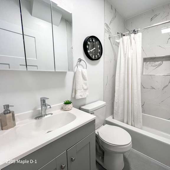 a bathroom with a white toilet, sink, and bathtub.