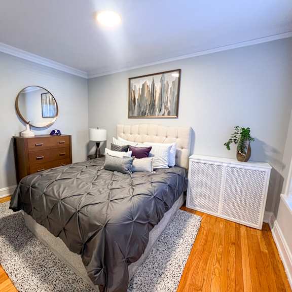 a bedroom with a bed, nightstand, and a painting on the wall.