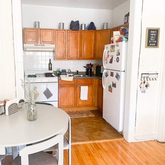 a kitchen with a white fridge and wooden cabinets.