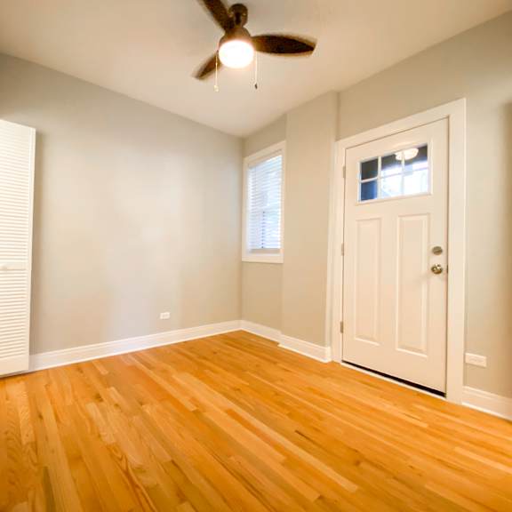 a room with a ceiling fan and wooden floors.