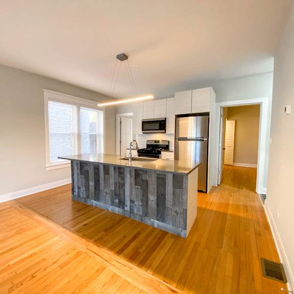 a kitchen with a wooden floor and a grey counter.