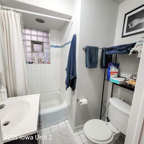 a white toilet is in a bathroom with a white sink and a white bathtub.