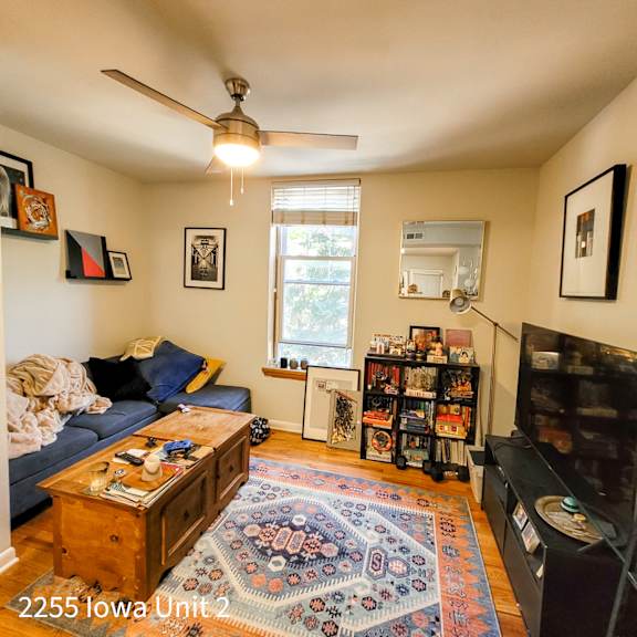 a living room with a rug on the floor and a couch with pillows.