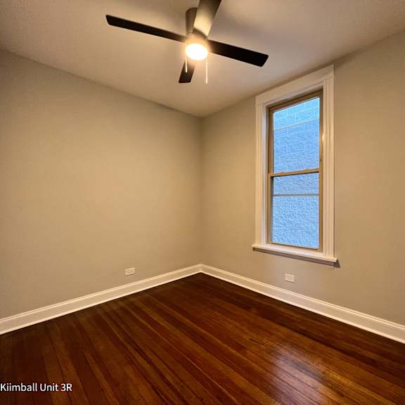 a room with a window and a ceiling fan.
