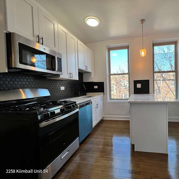 a kitchen with black and white appliances and cabinets.