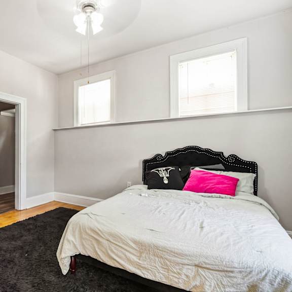 a bedroom with a bed, pillow, and a rug.