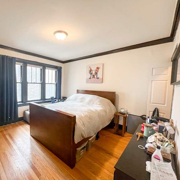 a bedroom with a bed, nightstand, and window.