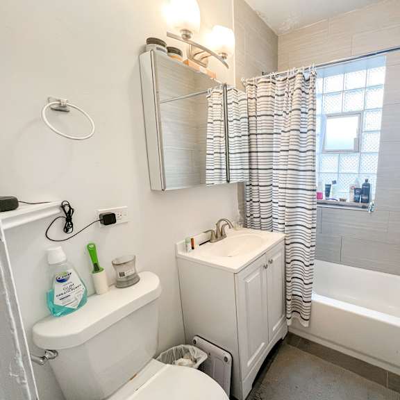 a white bathroom with a toilet, sink, and bathtub.