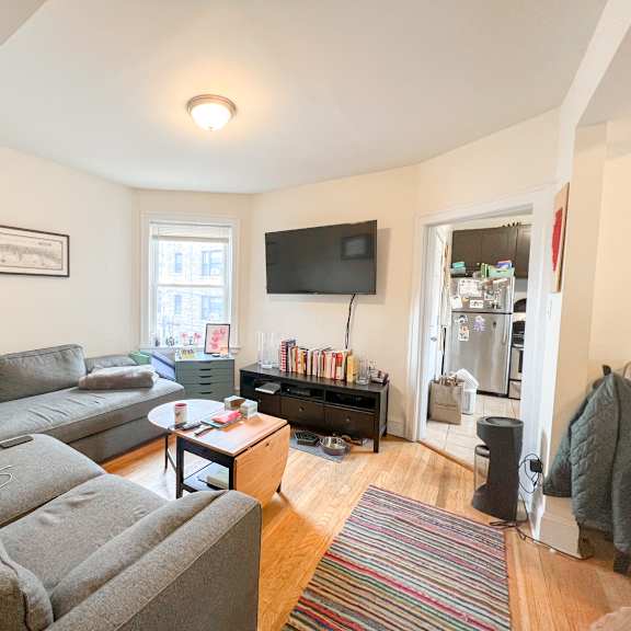 a living room with a grey sofa and a television.
