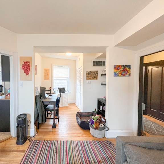 a living room with a couch and a striped rug.