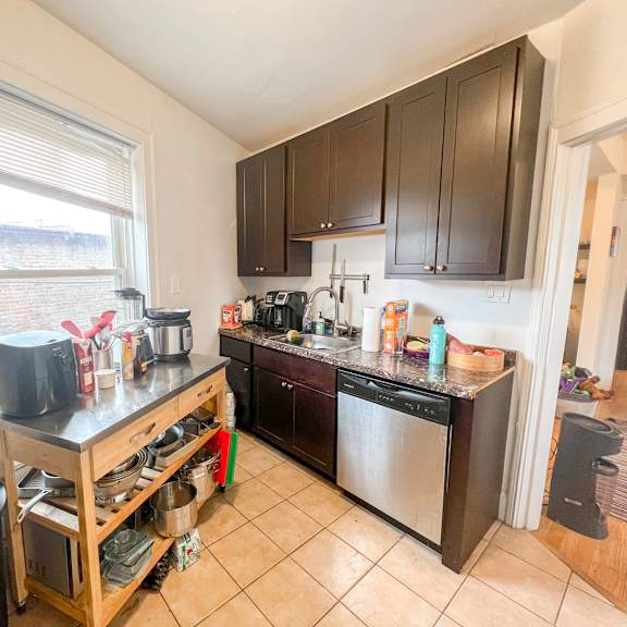 a kitchen with a black counter top and wooden cabinets.