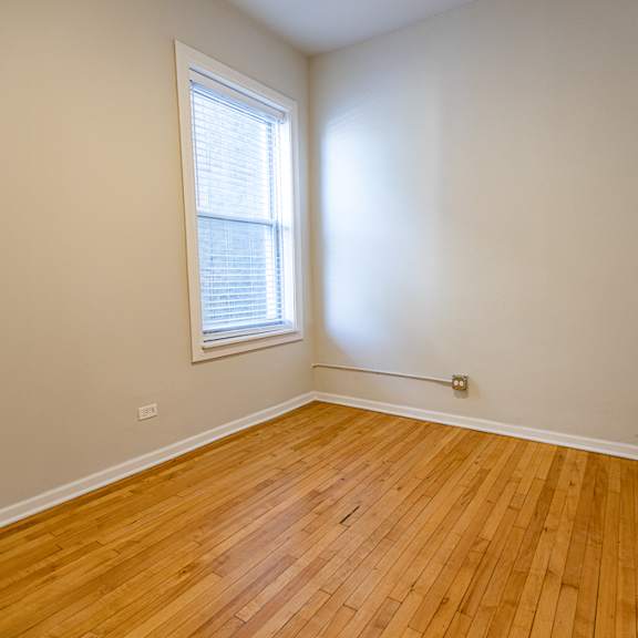 a room with wooden flooring and a window.