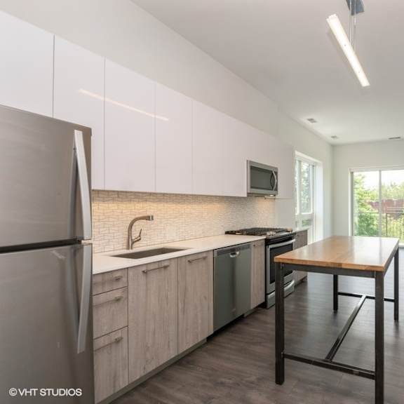 a kitchen with a table and a refrigerator and a sink