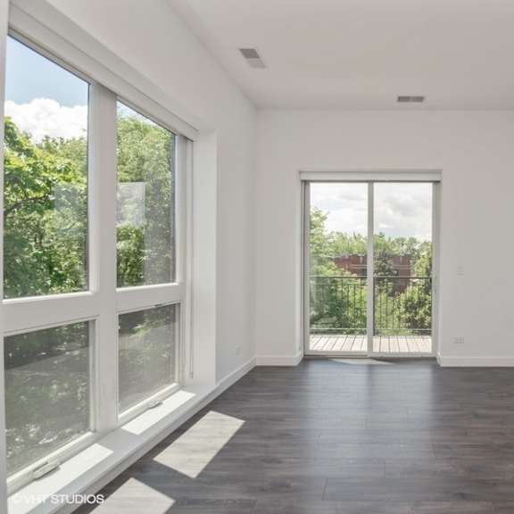 a living room with large windows and a door to a balcony