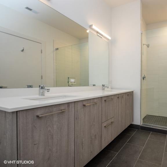 a bathroom with a shower and a sink and a mirror
