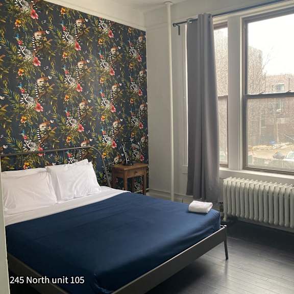 a bedroom with a bed and a radiator and a window