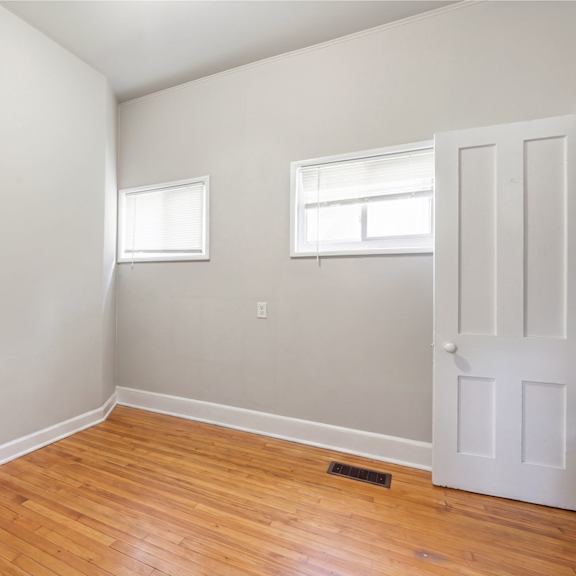 a room with a white door and two windows.