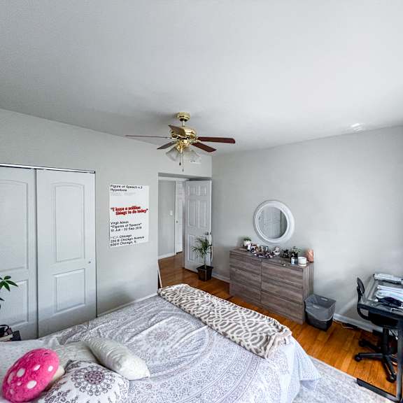 a bedroom with a bed, desk, and chair.
