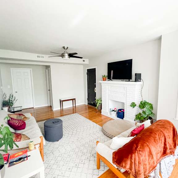 a living room with a white fireplace, a television, and a couch.