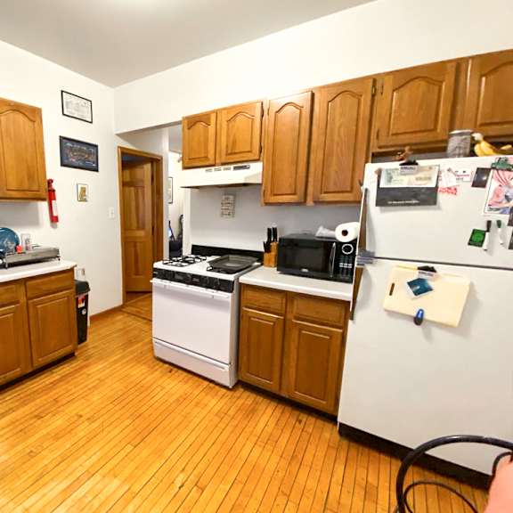 a kitchen with wooden cabinets and a white fridge.