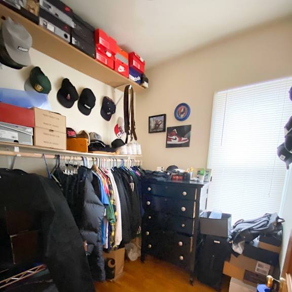 a room with a lot of clothes and hats hanging on the wall.