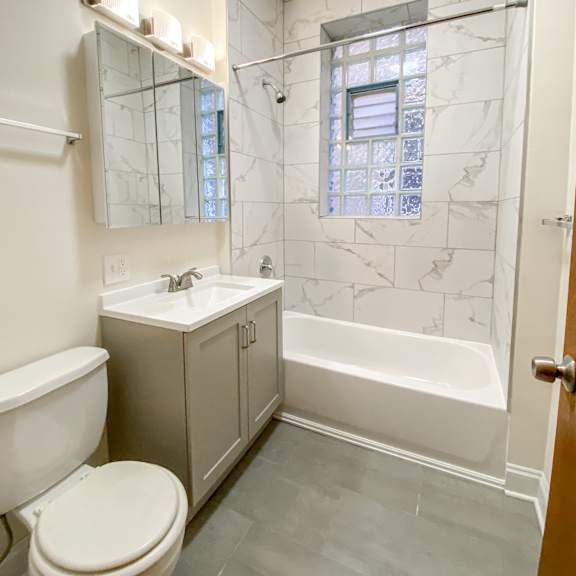 a white toilet sits next to a sink in a bathroom.