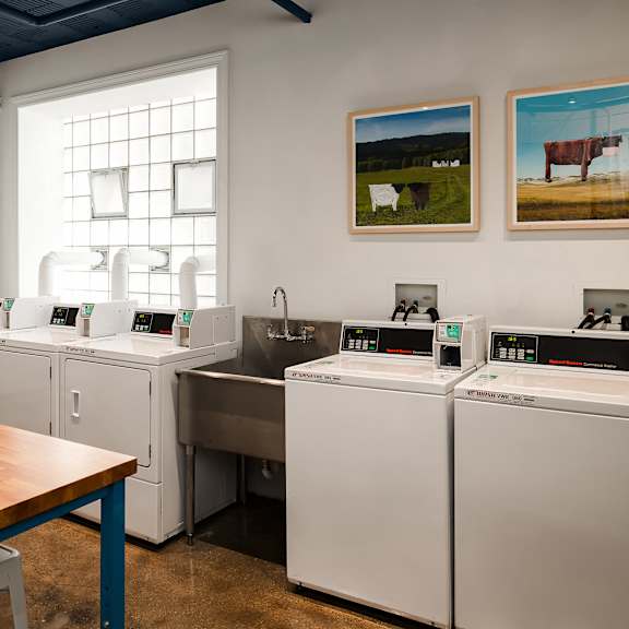 a kitchen with a table, chairs, and a calendar on the wall.