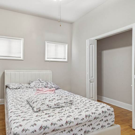 a bedroom with a bed and two windows.