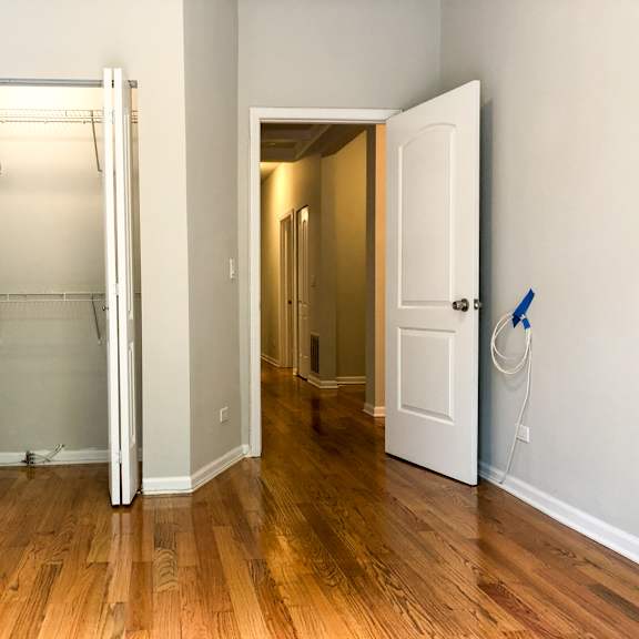 an empty room with a closet and a door open to a bathroom
