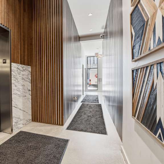 a hallway with a marble floor and a wooden wall.