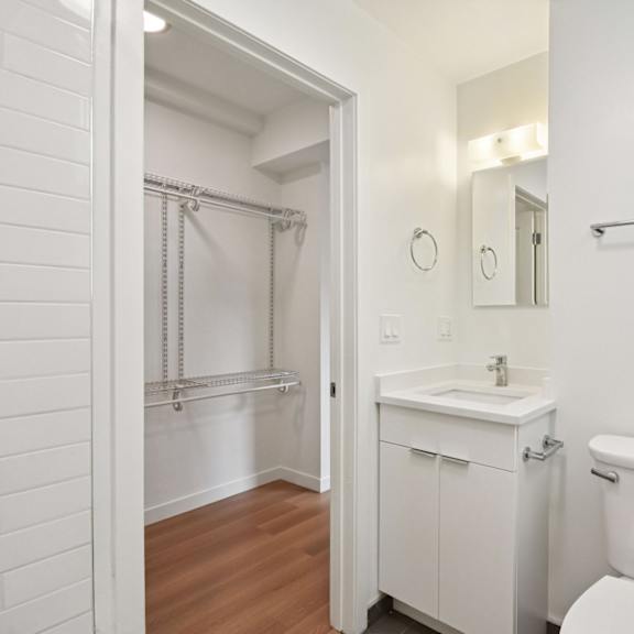 a white bathroom with a toilet, sink, and a shower.