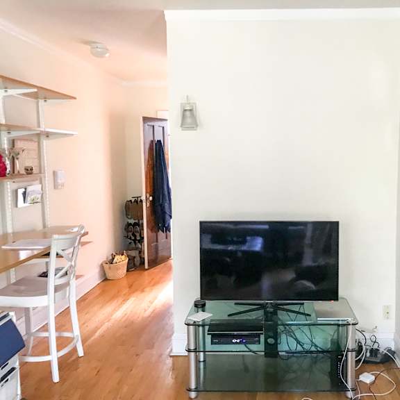 a living room with a flat screen tv and a glass coffee table.