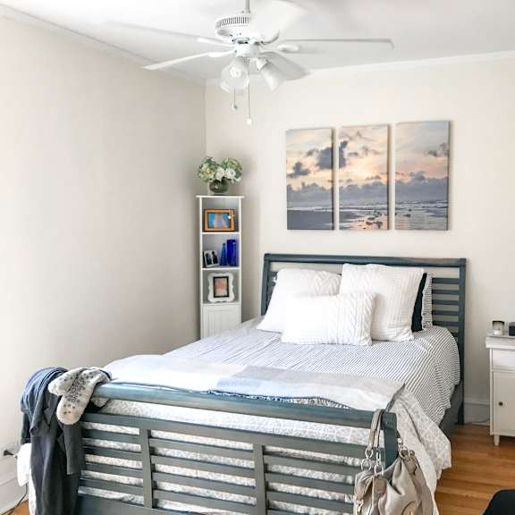 a bedroom with a bed, nightstand, and a painting on the wall.