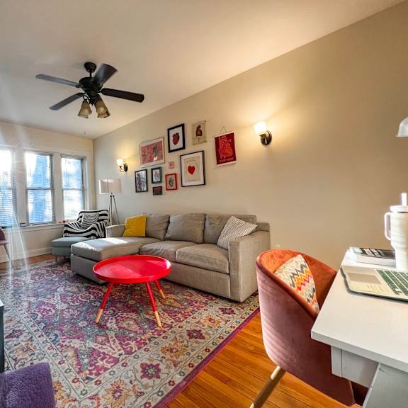a living room with a couch, a chair, a table, and a rug.
