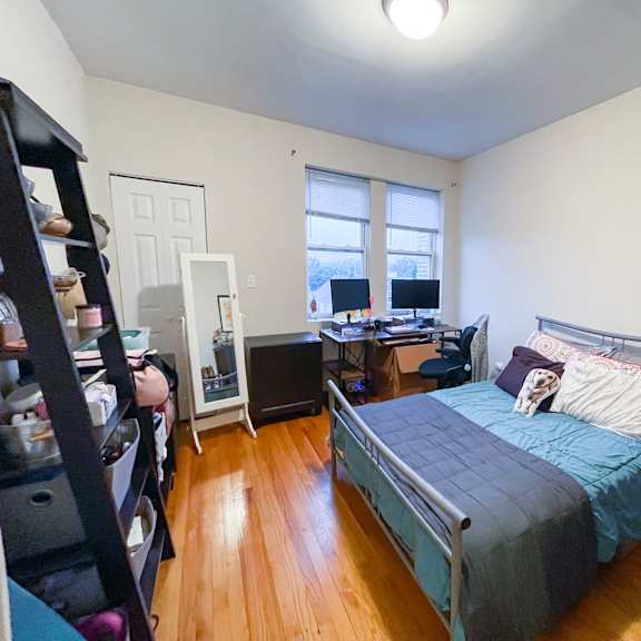 a bedroom with a bed, desk, and chair.