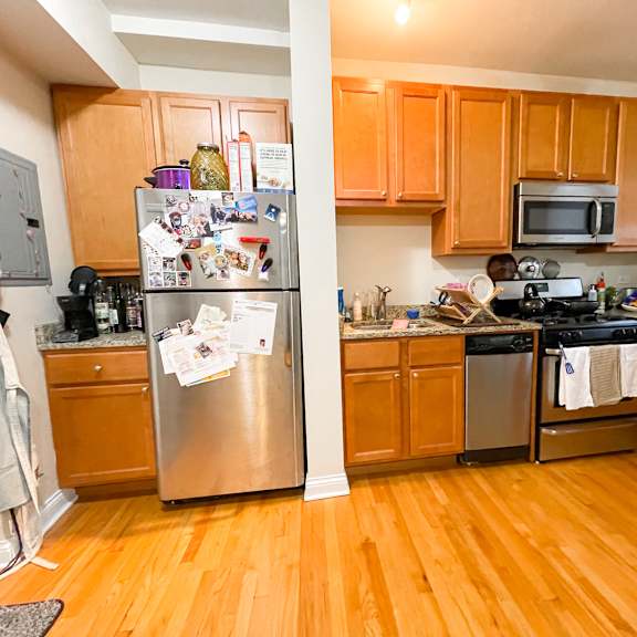 a kitchen with wooden cabinets and a refrigerator with many magnets on it.