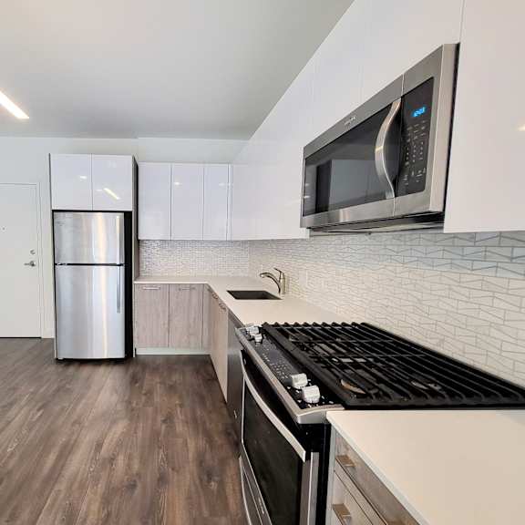 a kitchen with white cabinets and a stainless steel refrigerator