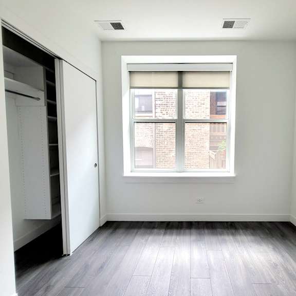an empty room with a window and a closet