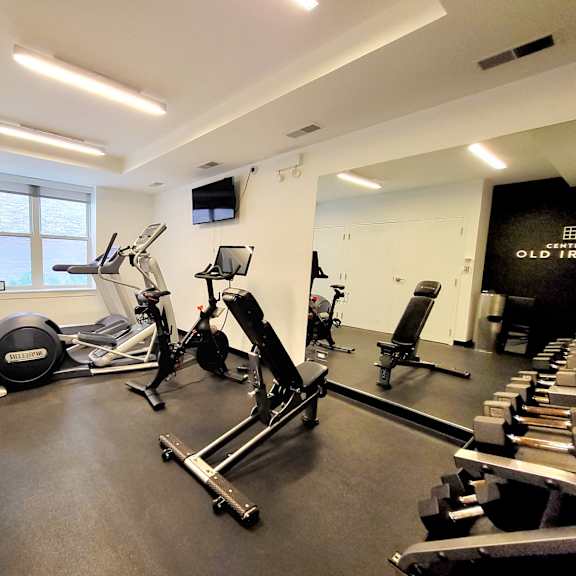 a gym with cardio machines and weights on the floor
