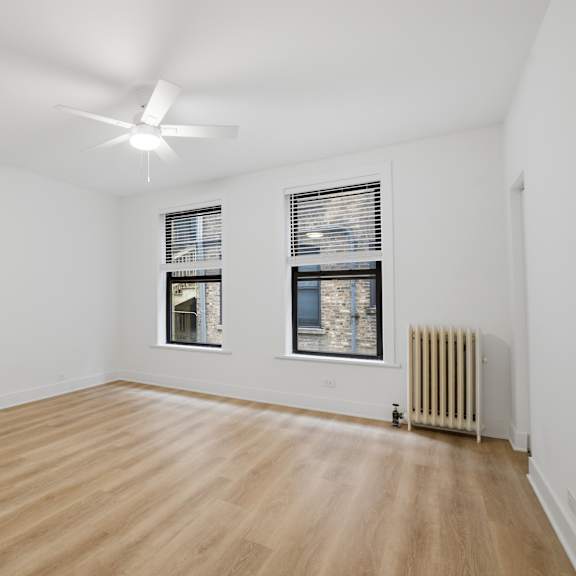 a room with wooden flooring and a ceiling fan.