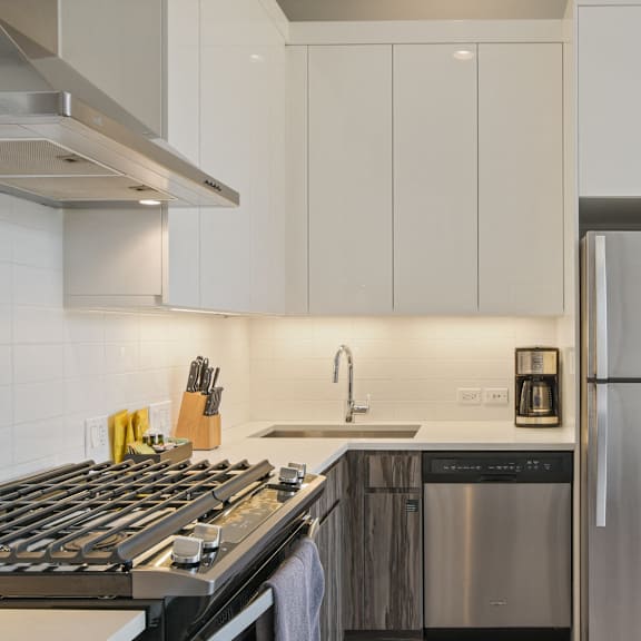 a kitchen with white cabinets and stainless steel appliances and a window