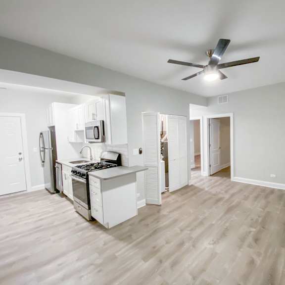 a kitchen with a refrigerator, microwave, and oven.