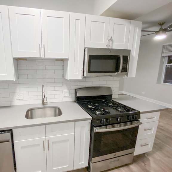 a kitchen with white cabinets and a black stove top oven.