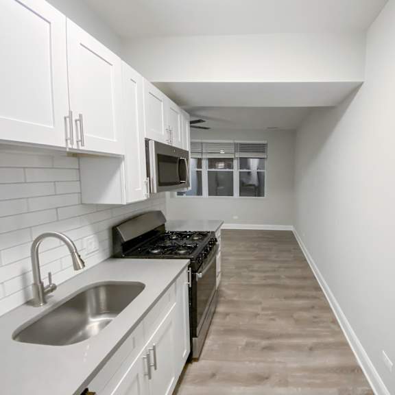 a kitchen with white cabinets and a black stove top oven.