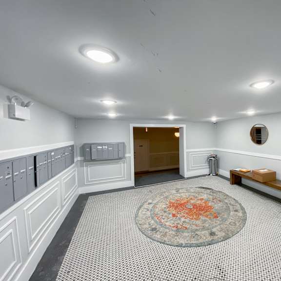 a hallway with a tiled floor and a round rug in the middle.