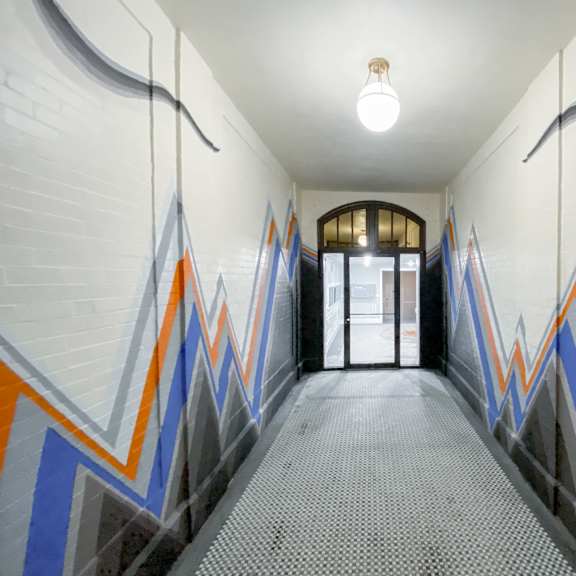 a hallway with a white brick wall and a light on.